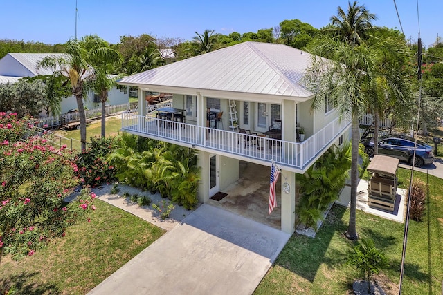 view of front of home with a front yard, a carport, a balcony, and french doors