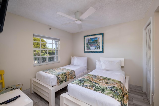 bedroom with ceiling fan and a textured ceiling