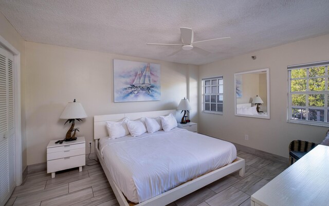 bedroom featuring ceiling fan, a closet, and a textured ceiling