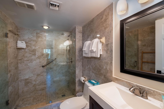 bathroom featuring vanity, toilet, an enclosed shower, and tile walls