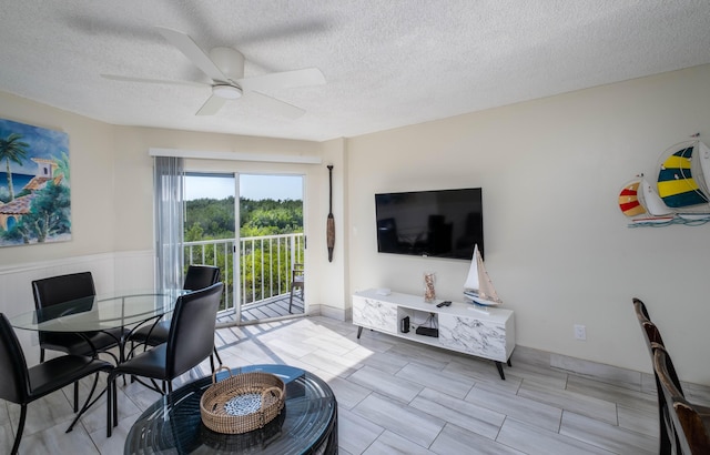 living room with a textured ceiling and ceiling fan