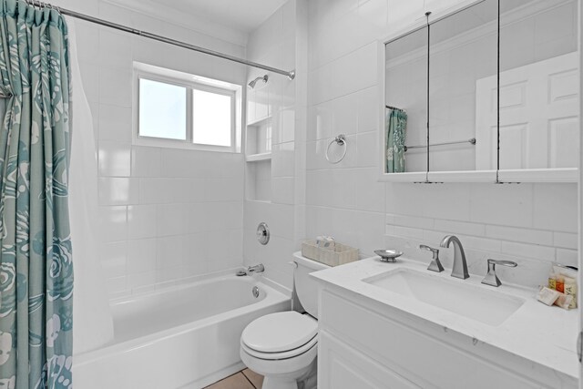 full bathroom with toilet, tasteful backsplash, tile walls, vanity, and shower / bath combo