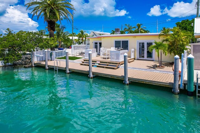 dock area with a patio area and a water view