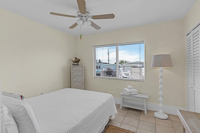 tiled bedroom featuring ceiling fan