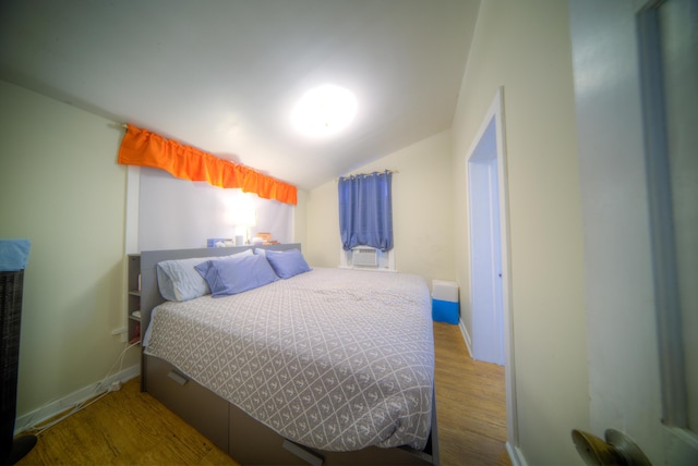 bedroom featuring hardwood / wood-style flooring and vaulted ceiling