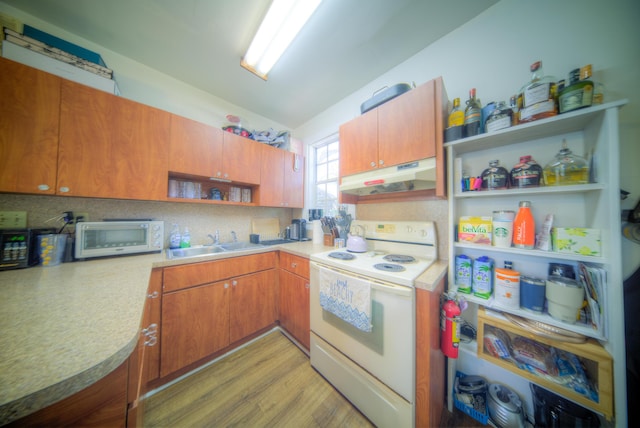 kitchen with sink, white appliances, light hardwood / wood-style floors, decorative backsplash, and vaulted ceiling