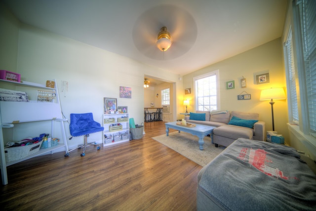 living room with dark wood-type flooring and ceiling fan