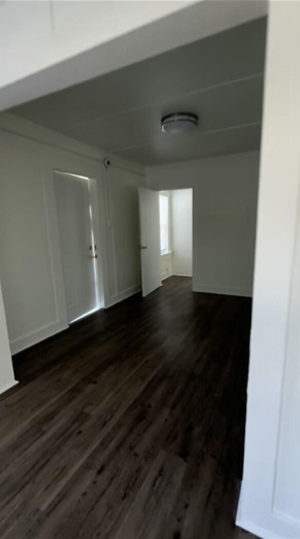 unfurnished room with dark hardwood / wood-style floors