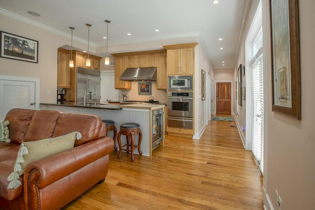 810 Terry Ln, Key West, FL 33040 - kitchen featuring built in appliances, wall chimney exhaust hood, a warming drawer, open floor plan, and light wood finished floors