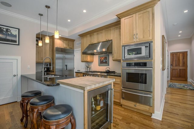 810 Terry Ln, Key West, FL 33040 - kitchen featuring built in appliances, a warming drawer, wine cooler, extractor fan, and light wood-style floors