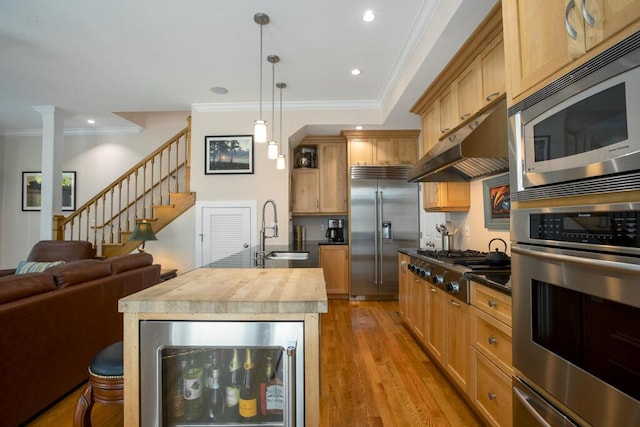 810 Terry Ln, Key West, FL 33040 - kitchen with built in appliances, wine cooler, under cabinet range hood, ornamental molding, and wood finished floors