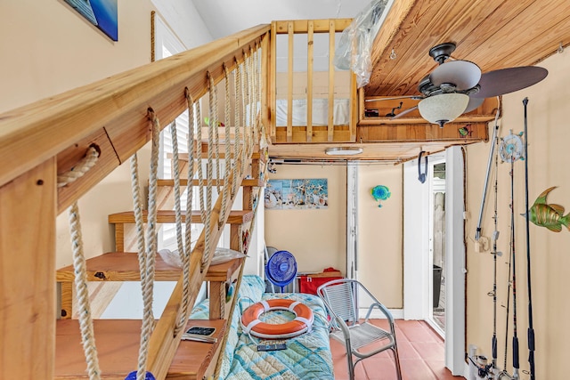 stairs featuring ceiling fan