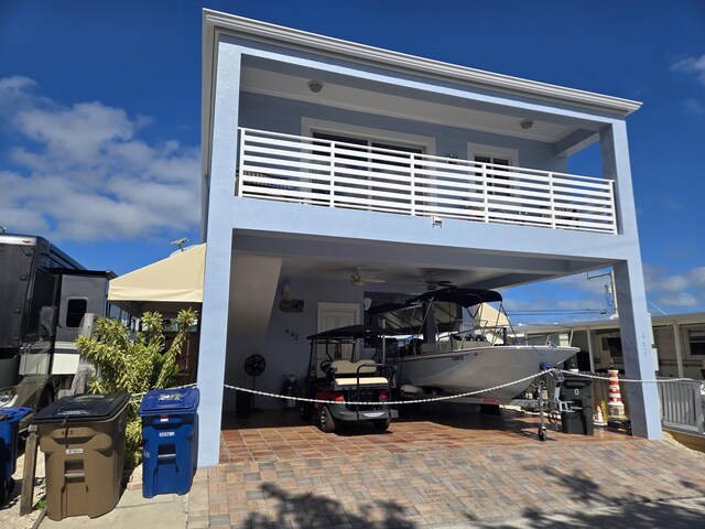 back of house with ceiling fan, a patio area, and a balcony