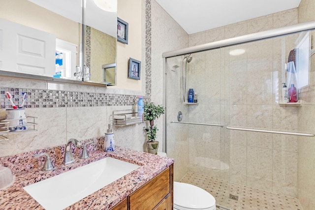 bathroom with vanity, toilet, tile walls, and walk in shower