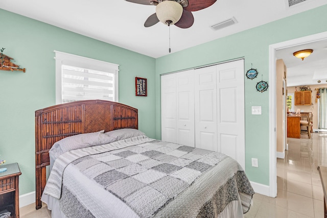 tiled bedroom featuring ceiling fan, a closet, and multiple windows