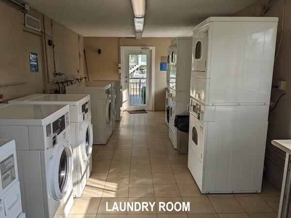 laundry area with stacked washer / drying machine, separate washer and dryer, and light tile patterned floors