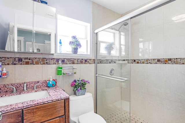 bathroom with toilet, vanity, decorative backsplash, and walk in shower