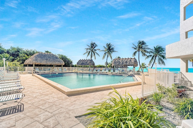 view of pool featuring a gazebo, a water view, and a patio area