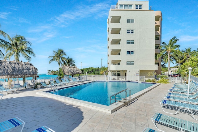 view of pool with a water view and a patio area