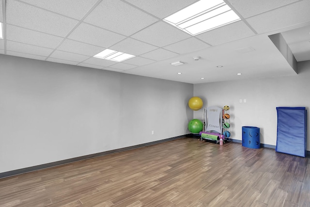 exercise room with hardwood / wood-style flooring and a paneled ceiling