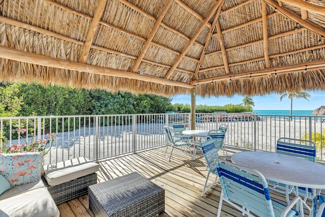 wooden deck featuring a view of the beach, a gazebo, and a water view