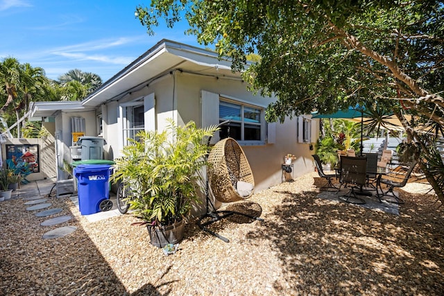 exterior space featuring stucco siding, outdoor dining area, and a patio area