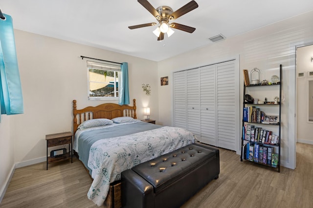 bedroom with a closet, baseboards, visible vents, and wood finished floors