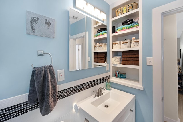 bathroom featuring visible vents, vanity, and decorative backsplash