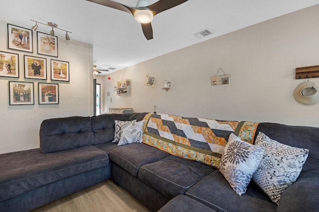 living room with visible vents, wood finished floors, and ceiling fan