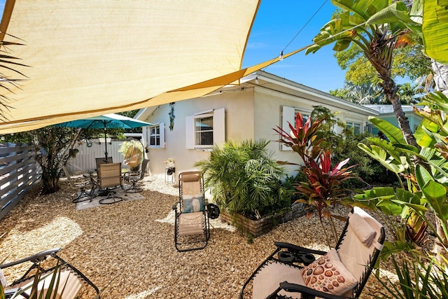 exterior space with outdoor dining space, stucco siding, a patio, and a fenced backyard