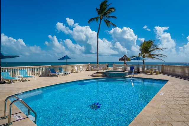 view of pool with a patio area, a community hot tub, and a water view