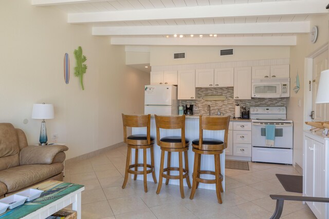 kitchen featuring tasteful backsplash, white appliances, lofted ceiling with beams, and white cabinets