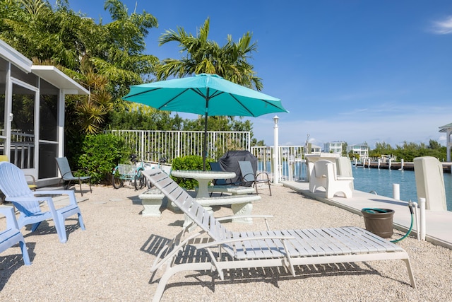 view of patio / terrace with a water view and a boat dock