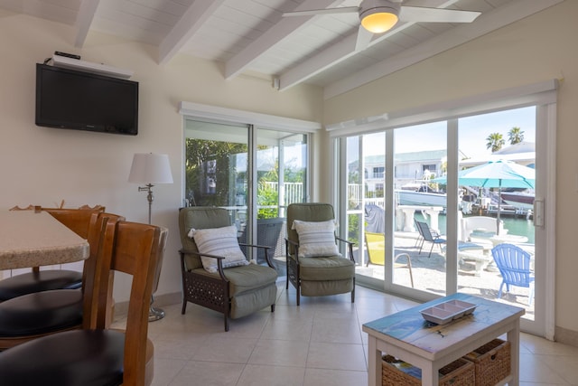 interior space featuring a water view, ceiling fan, light tile patterned floors, and vaulted ceiling with beams