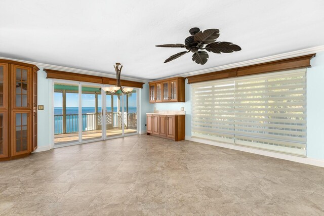 unfurnished living room with ornamental molding, ceiling fan, and a water view