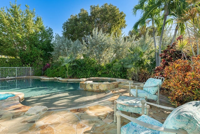 view of pool with a patio and an in ground hot tub