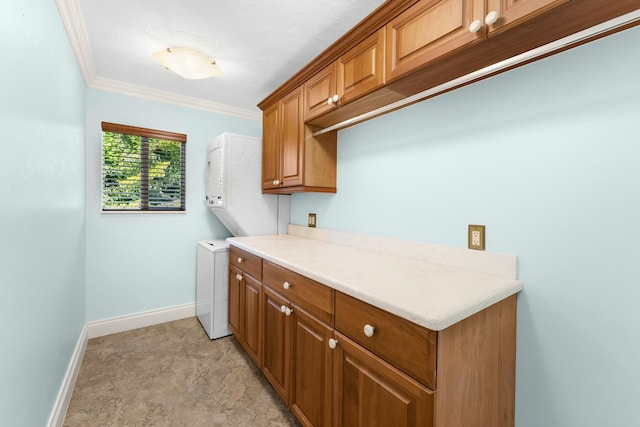 laundry room with cabinets, ornamental molding, and stacked washer and clothes dryer