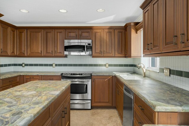 kitchen with light stone countertops, appliances with stainless steel finishes, sink, and decorative backsplash