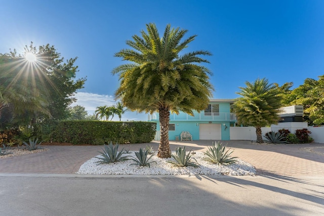 view of property hidden behind natural elements featuring a garage