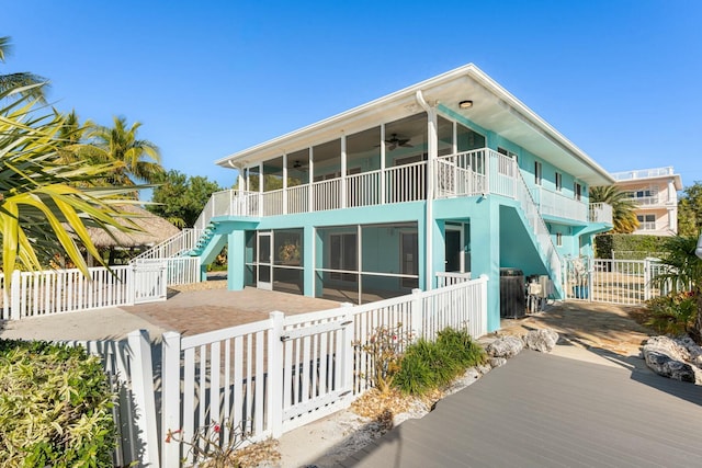 view of side of home with a sunroom and ceiling fan