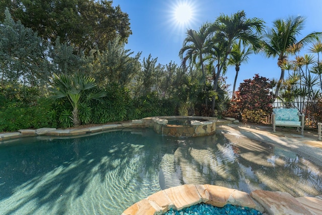 view of swimming pool with an in ground hot tub