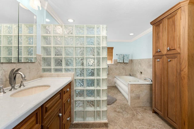 bathroom with vanity, tiled bath, crown molding, and tile walls