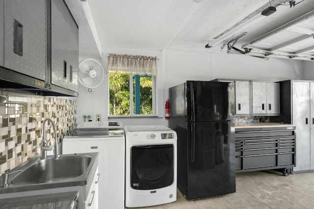 washroom featuring washer and dryer, sink, and light tile patterned floors