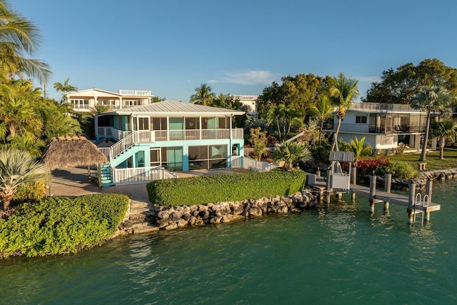 back of house featuring a sunroom and a water view