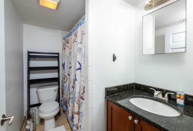 bathroom with tile patterned flooring, vanity, and toilet