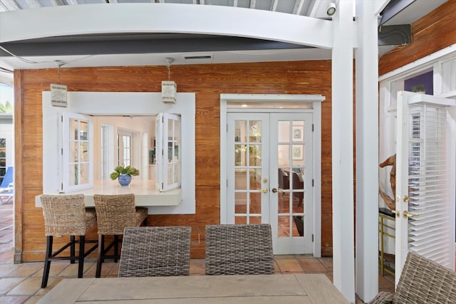 dining area featuring french doors and wood walls