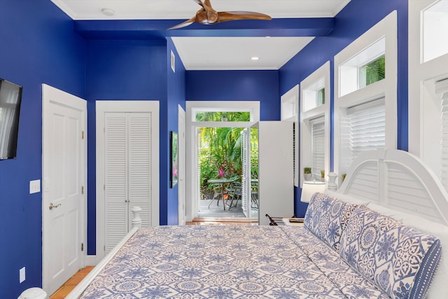 bedroom with crown molding, ceiling fan, and a closet