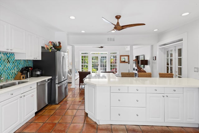 kitchen with white cabinetry, decorative backsplash, stainless steel dishwasher, and french doors