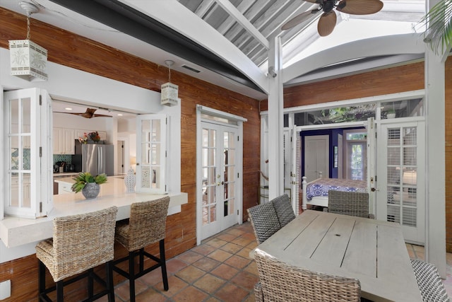 interior space with vaulted ceiling with beams, ceiling fan, and french doors