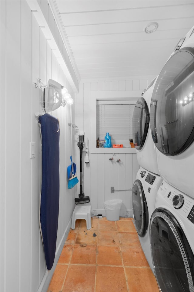 clothes washing area featuring ornamental molding, stacked washer / drying machine, and tile patterned floors